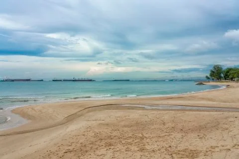 Winding beach with cloudy sky Stock Photos