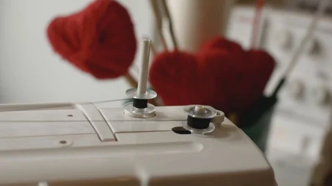 Winding black thread from one sewing bobbin to another on a white sewing machine Stock Footage 128966701