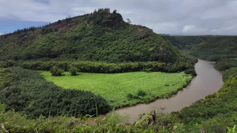Winding brown river curving through a lush green valley in Hawaii Stockbeeldmateriaal 347826166