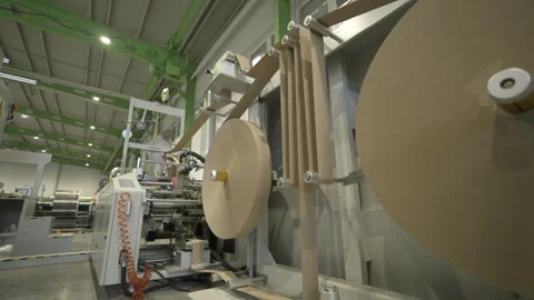 Winding cardboard onto rolls using machine parts in shop Vídeo Stock 296577877
