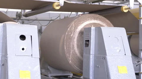 Winding cardboard web onto large rolls in factory workshop Stock Footage 303104409