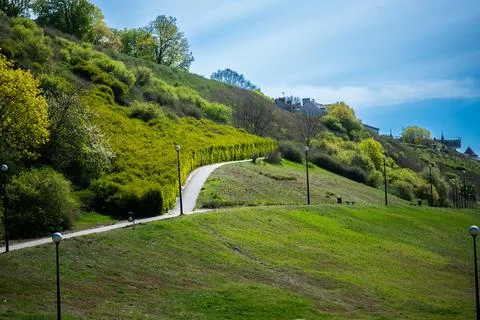 Winding cobbled path leading to a steep green hill on a beautiful sunny day Фото