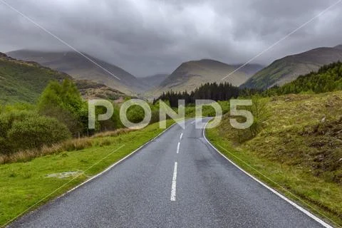 Winding Country Road And Hills With Overcast Sky At Glen Nevis Near Fort William