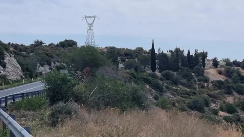 Winding Cyprus road through hillside with cypress trees and power line Stock Footage 328095147