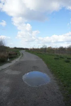 Winding Dirt Path With Sky Reflection Puddle In North East Derbyshire, England. Stock Photos