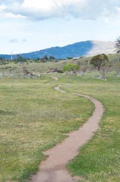 Winding dirt path through an open field Stock Photos