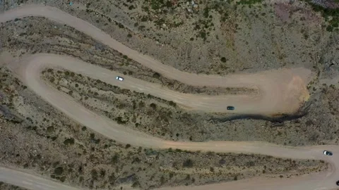 Winding dirt road going down a grime canyon on the desert Stock Footage 264095459