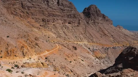 Winding Dirt Road Through Arid Mountains of Oman Stock Footage 318623975