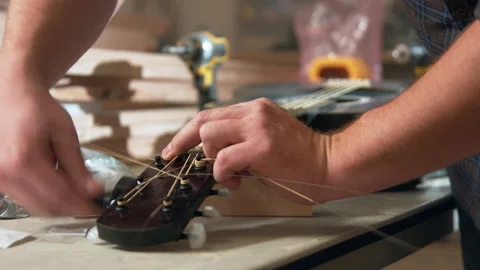Winding guitar strings in re stringing with new strings. Stock Footage 139664964