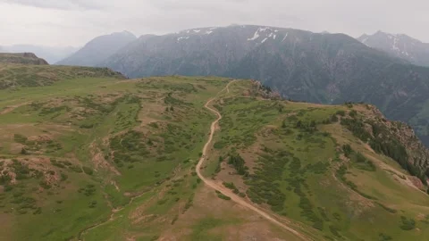 Winding mountain path through lush green valley Video stock 312451141