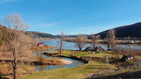 The winding mountain river flows into a calm large river. Stock Footage 106275978