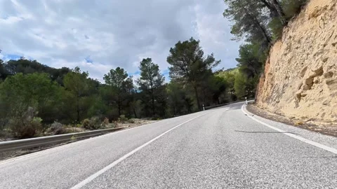 The Winding Mountain Road is beautifully surrounded by lush, vibrant greenery Stock Footage 311222398
