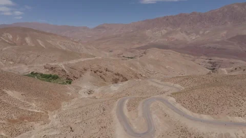Winding mountain road cutting through arid desert hills Stock Footage 292830047