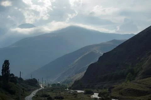 Winding mountain road leading into dramatic valley landscape Stock Photos