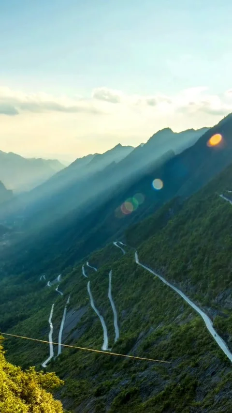 Winding mountain road with sharp curves through green valley Video stock 331935317