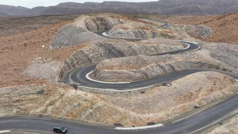 Winding Mountain Road with Sharp Switchbacks in Rocky Terrain Stock Footage 336617917