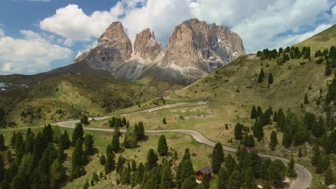 Winding mountain road through alpine valley with dramatic peaks Vidéo 337079304