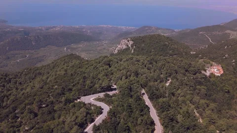 Winding Mountain Road Through Green Hills Above the Sea in Greece Stock Footage 337864764