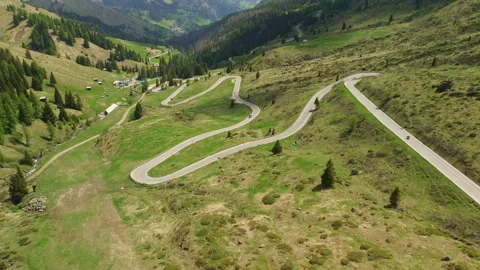 Winding mountain road through lush green valley Vidéo 337079027