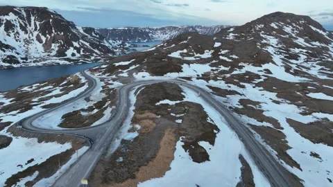 Winding Mountain Road Through Snow Patches and Remote Alpine Landscape. Nor.. Stock Footage 321784568