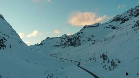 Winding mountain road through snowy alpine valley Stock Footage 341607582