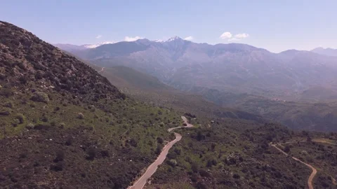 Winding Mountain Road Toward Snow Capped Peaks in Greece Stock Footage 337864928