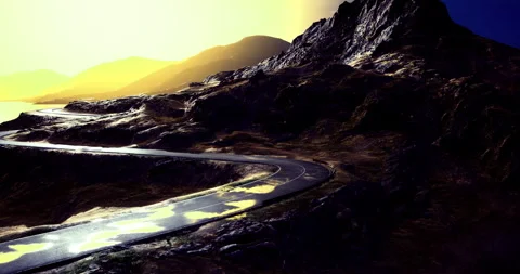 Winding mountain road under a dramatic sunset sky with vibrant colors Stock Footage 306302881