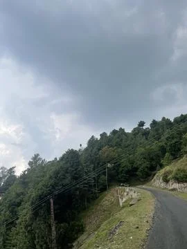 Winding Mountain Road Under a Dramatic Sky Stock Photos