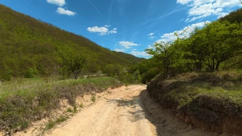 Winding path cuts through lush forested slopes. Balkan, Eastern Europe, POV Video stock 333589822