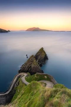 A winding path on Dingle Peninsula leads to cliffs above the ocean Foto stock