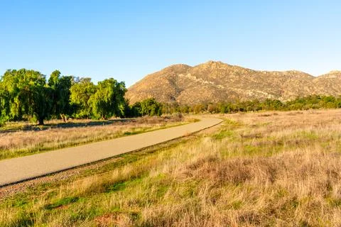 Winding Paved Path Through Grassy Field and Mountains at Lake Perris Stock-Fotos