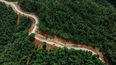 Winding Paved Road Under Construction Through Lush Green Tropical Forest Hi.. Фото