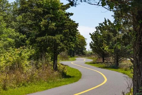 Winding Paved Trail Through Forest on Sunny Day in Gateway National Park Stock Photos
