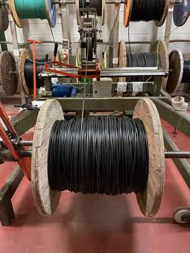 Winding process with electric cable machine on wooden spools Stock Photos