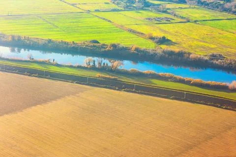 Winding river divides a patchwork of green fields 스톡 사진