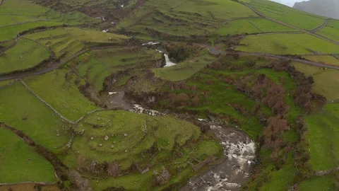 Winding river flows among green hills. Aerial of misty Flores island, Azores Stock Footage 121269917