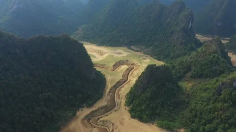 Winding river meandering through lush green valley Vídeo Stock 311875445