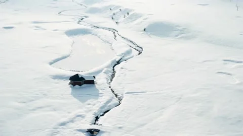 Winding river or stream cuts through the snowy terrain. Stock Footage 297869231