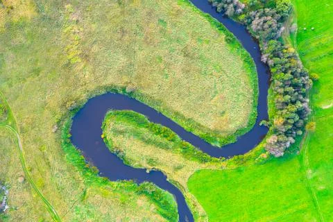 Winding river on a plain with trees and meadows on the shore, aerial view. Fotos Stock