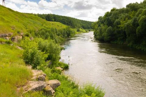 Winding river on a riffle in a summer forest in cloudy weather with rain clou Stock Photos