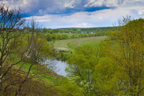 Winding river in a summer forest in cloudy weather with rain clouds. Landscap Stock Photos