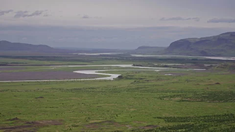 Winding River Through Green Plains in Icelandic Valley Stock Footage 319699581