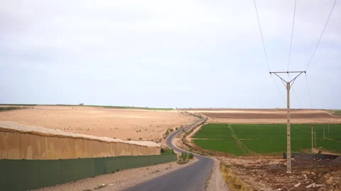 Winding Road Between Arid Desert and Green Irrigated Fields in Morocco Vídeos de archivo 334180954