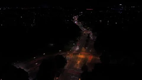 Winding road curves through dense forested hills toward glowing intersection Stock Footage 347701084
