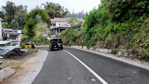 Winding road curves through lush green hills Stock Footage 345152580