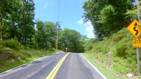 Winding Road Drive through forest with blue sky on a clear sunny day Stock Footage 135670649