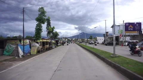 Winding road in a green hilly area with a vast natural view under a cloudy sky. Vidéo 333973385