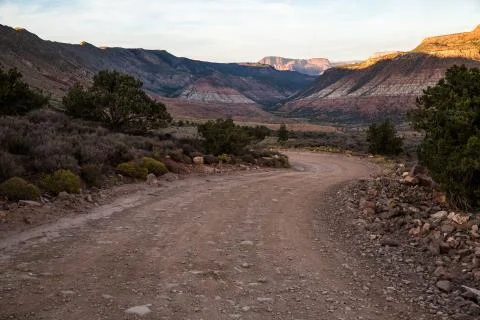 Winding road in shadow at sunset through the desert of Southern Utah Stock Photos