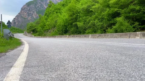 Winding road through green forest and mountain cliff scenic view Stock Footage 310246849