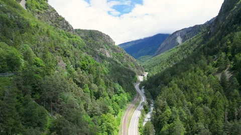 Winding road through lush green mountains under a bright sky offers breathtaking Video stock 314079859